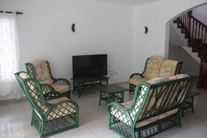 ein Wohnzimmer mit Stühlen und einem Flachbild-TV in der Unterkunft Island Of Love in Mahé