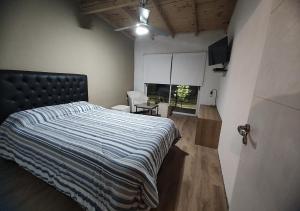 a bedroom with a bed with a blue and white comforter at Hospedaje MP canning in Ezeiza