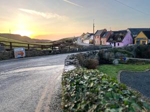 an empty road with houses and the sunset in the background at Greene Acres - Room Only in Doolin