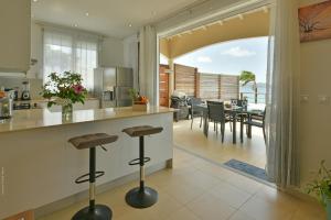a kitchen and dining room with a view of the ocean at Villa Yvantino in Saint Barthelemy