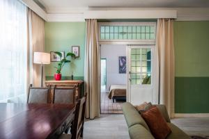 een woonkamer met een tafel en een kamer met een slaapkamer bij Hotel Nieuw Antiek in Helden