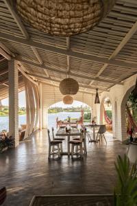 um pavilhão com uma mesa, cadeiras e água em Casa na Lagoa em Paracuru