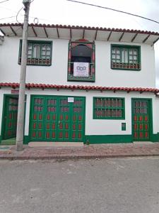 een gebouw met groene en rode deuren in een straat bij ApartaHotel Monguí in Monguí