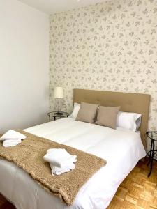 マドリードにあるApartamento Madrid Centroのベッドルーム(白い大型ベッド、毛布付)
