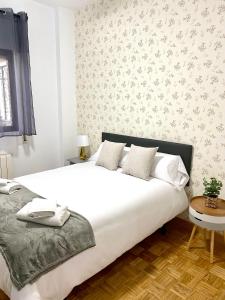 マドリードにあるApartamento Madrid Centroのベッドルーム(白いシーツを使用した大型ベッド1台付)