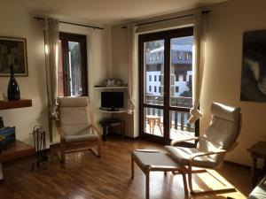 a living room with two chairs and a window at Appartamento Mountain Paradise Ponte di Legno Tonale in Ponte di Legno