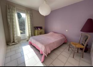 ein Schlafzimmer mit einem Bett, einem Stuhl und einem Fenster in der Unterkunft Villa et maisonnette provençales in Carpentras