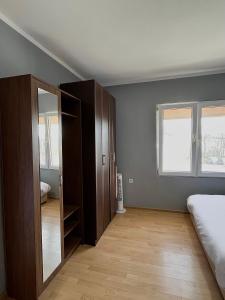 a bedroom with a bed and a closet and a window at Old Town Bar Apartments in Stari Bar