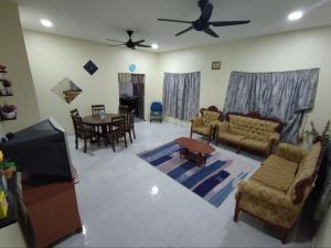 uma sala de estar com um sofá e uma sala de jantar em Man Homestay em Kampong Bukit China