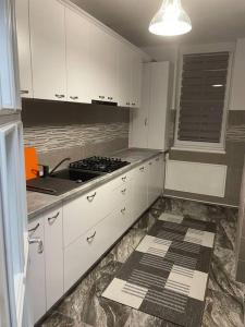 a kitchen with white cabinets and a stove top oven at Lovely 1 bedroom apartment with parking in Iaşi