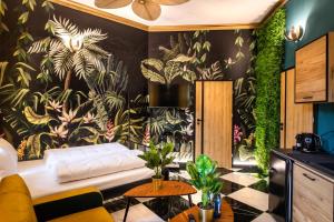 a living room with a wall mural of plants at Jungle Apartments Podwale in Wrocław