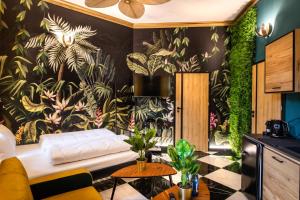 a living room with a wall mural of plants at Jungle Apartments Podwale in Wrocław