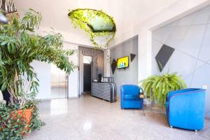a lobby with blue chairs and potted plants at Nice Hotel Yerevan in Yerevan