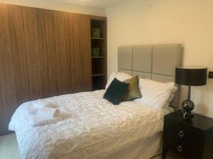 - une chambre avec un grand lit blanc et une table de nuit dans l'établissement Dockside Sleeps 8, Uber Boat to Canary Wharf in 3 mins, à Londres