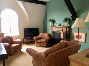 uma sala de estar com um sofá e cadeiras e uma lareira em Charming 2-Bed Apartment in Waterloo Liverpool em Liverpool