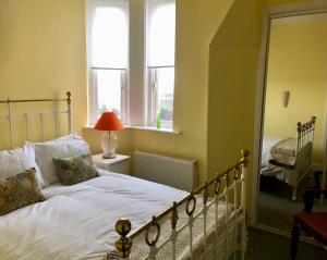 利物浦的住宿－Charming 2-Bed Apartment in Waterloo Liverpool，一间卧室设有床、两个窗户和镜子