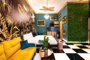 a living room with a bed and a yellow couch at Jungle Apartments Podwale in Wrocław