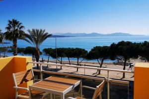 un tavolo e sedie su un balcone affacciato sulla spiaggia di SoléRio - Studio Climatisé Face à la mer a La Ciotat