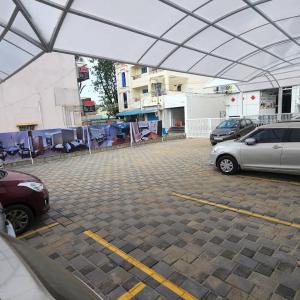 parking z dwoma samochodami zaparkowanymi pod namiotem w obiekcie Hotel Sivas Regency w mieście Theni