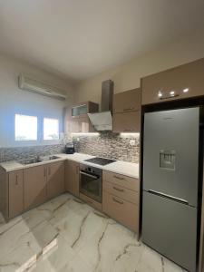 een keuken met een koelkast en een fornuis top oven bij Theodore resort in Áyios Yeóryios