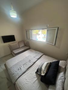 1 dormitorio con 1 cama grande y 1 sofá en Theodore resort, en Áyios Yeóryios