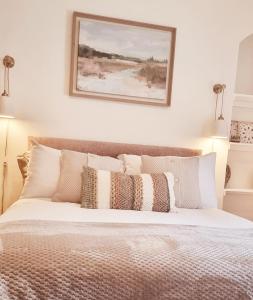 een slaapkamer met een groot bed met kussens erop bij Churchview in Townhill