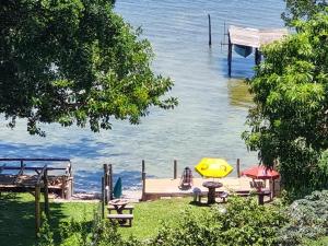 un muelle sobre el agua con una mesa y bancos en Casas de Férias Laguna en Laguna