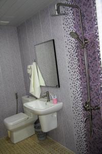 a bathroom with a toilet and a sink and a shower at Nice Hotel Yerevan in Yerevan