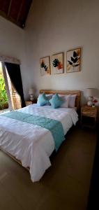 1 dormitorio con 1 cama blanca grande con almohadas azules en Your Secret Garden Villa - Melasti Beach! en Ungasan