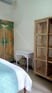 1 dormitorio con cama, mesa y estanterías en Your Secret Garden Villa - Melasti Beach! en Ungasan