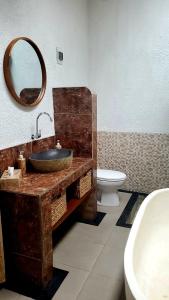 y baño con lavabo, aseo y espejo. en Your Secret Garden Villa - Melasti Beach! en Ungasan