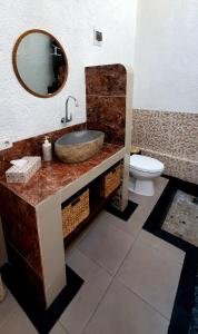 y baño con lavabo, espejo y aseo. en Your Secret Garden Villa - Melasti Beach! en Ungasan