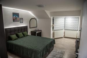 a bedroom with a green bed and a window at Happy in Pirot