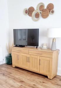 a television on a wooden cabinet in a living room at Churchview in Townhill