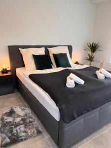 a large bed with two stuffed animals on it at LUX Business Apartments in Weil am Rhein