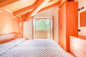 a bedroom with a large bed and a window at Residence Toli in Ledro