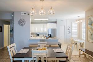 una cucina e una sala da pranzo con tavolo e sedie di Beach Colony West Penthouse 2A By Pkrm a Pensacola