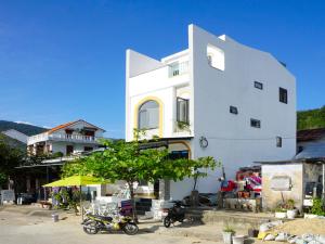 un edificio bianco con moto parcheggiate di fronte di Chàm’s Corner Lookout Homestay & Restaurant a Tân Hiệp