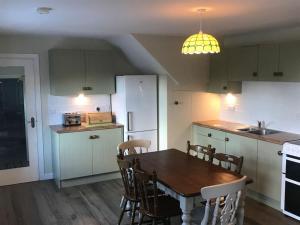 una cucina con tavolo e sedie e una sala da pranzo di Mournes Family Cottage with Hot Tub a Hilltown