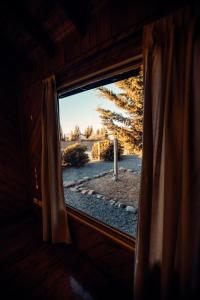 uma janela num quarto com vista para um campo em Paraiso Patagónico Bungalows and Apart Hotel em El Calafate