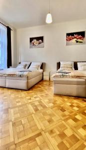 two beds in a room with a wooden floor at Spacious cozy apartments in centre in Prague
