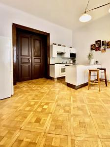 プラハにあるSpacious cozy apartments in centreのウッドフロアのキッチン、テーブルが備わります。