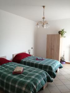 una camera con 2 letti e lenzuola verdi a quadri di 1000MigliaHouse a Brescia