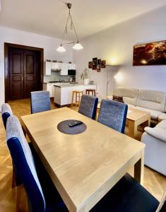 a living room with a wooden table and blue chairs at Spacious cozy apartments in centre in Prague