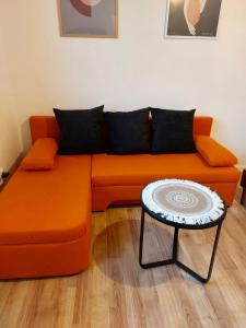 - un canapé orange avec une table dans le salon dans l'établissement Útulný apartmán v centre BB, à Banská Bystrica