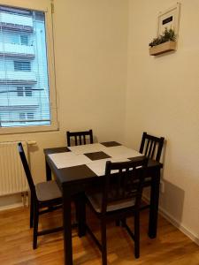 une table à manger avec quatre chaises et une fenêtre dans l'établissement Útulný apartmán v centre BB, à Banská Bystrica