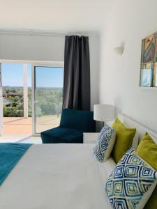 a bedroom with a white bed and a blue chair at Casa Branca Turismo Rural in Tavira +62 photos