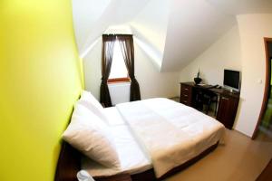 a bedroom with a white bed and a window at Grand hotel/pension in Sládkovičovo