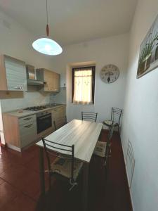 eine Küche mit einem Holztisch und Stühlen in der Unterkunft Casa Vacanze Il Geranio in Iglesias