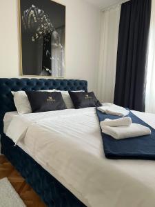 ein großes Bett mit schwarzweißer Bettwäsche und Kissen in der Unterkunft Mariposa in Smederevo